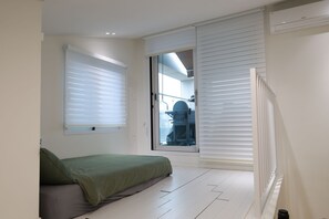 A bedroom with a bed, a window with blinds, a radiator, and a door leading to a balcony. - Seocho/Gangnam - Charming Family Home - 3-Story-Home - 15 Guests - 3BR/3BTH (Seoul)