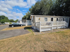A mobile home with a porch and a car parked in front. - Cabin Sleeps 4 to 6 with Parking (Ringwood)