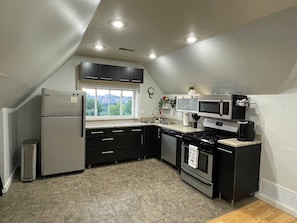 A compact kitchen with a refrigerator, microwave, stove, and sink. - 2 Apts • 3 Private Parking Spaces • Near CMU/Pitt (Pittsburgh)