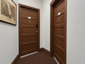 A hallway with two brown doors, each marked with a number. - 2 Apts • 3 Private Parking Spaces • Near CMU/Pitt (Pittsburgh)