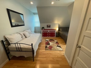 Ein Schlafzimmer mit einem Bett, einem Schminktisch, einem Spiegel und einem Teppich.