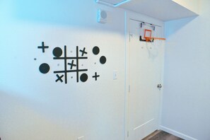 A room with a door, a basketball hoop, and a wall decoration. - Cozy Austin Getaway - Game Room - Minutes to UT (Austin)