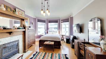 Ein Schlafzimmer mit Bett, Kommode, Spiegel und Kamin.