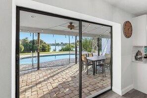 Une terrasse moderne avec une piscine, du mobilier d’extérieur et une vue sur un lac.