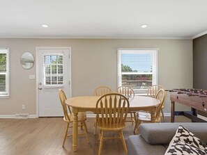 A dining area with a round table and chairs, a window with blinds, and a foosball table. - Maynard Meadow 721-Pet Friendly-Sleeps 6 (Columbia)