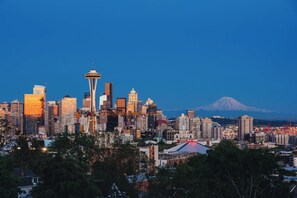 A city skyline with a prominent tower and a mountain in the background. - Queen Anne Home, Space Needle Walk + Parking (Seattle)