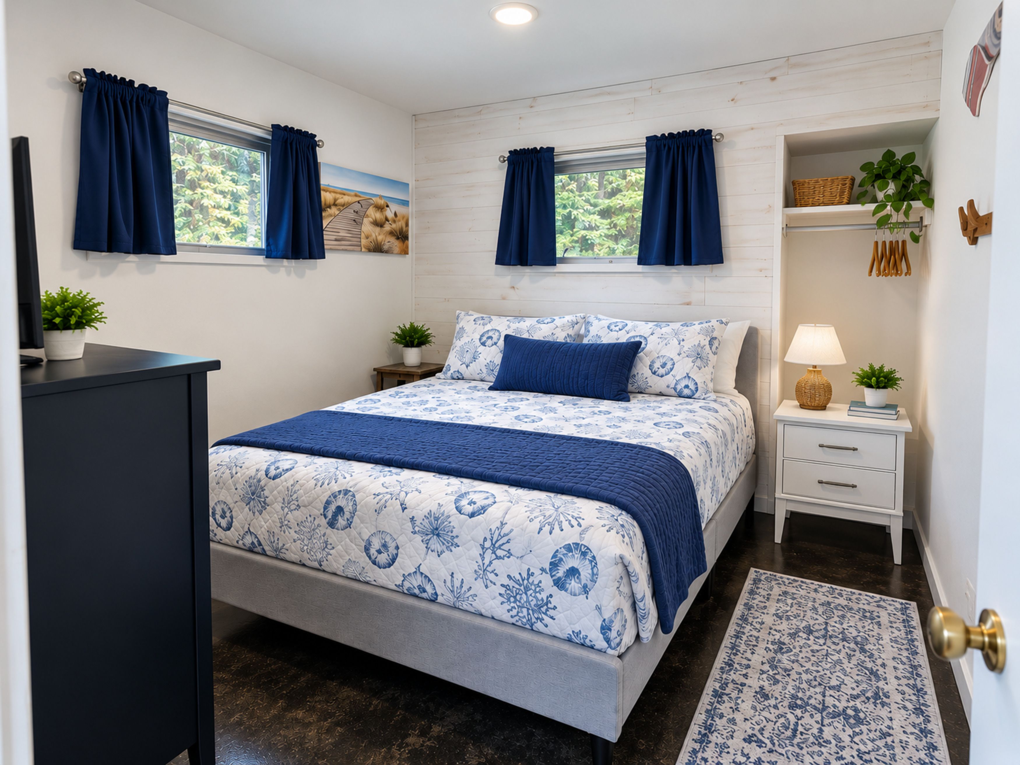 Un dormitorio con cama, mesitas de noche, un escritorio y una ventana con cortinas.