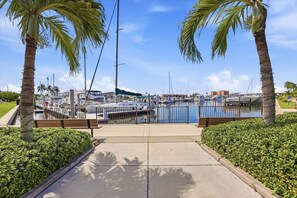 A marina with boats docked, a clear sky, and a pathway leading to the water. - Burnt Store Marina 2 Bedroom Condo (Punta Gorda)