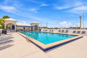 A swimming pool with lounge chairs and a covered area with a sign that reads 'WORKOUT'. - Burnt Store Marina 2 Bedroom Condo (Punta Gorda)