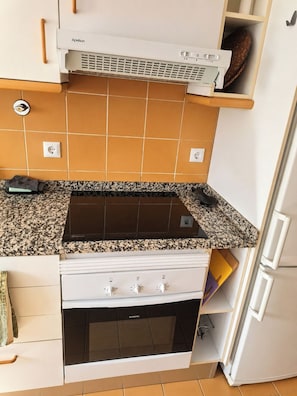 Een keuken met een Bosch inductiekookplaat, een Siemens oven en een witte koelkast.