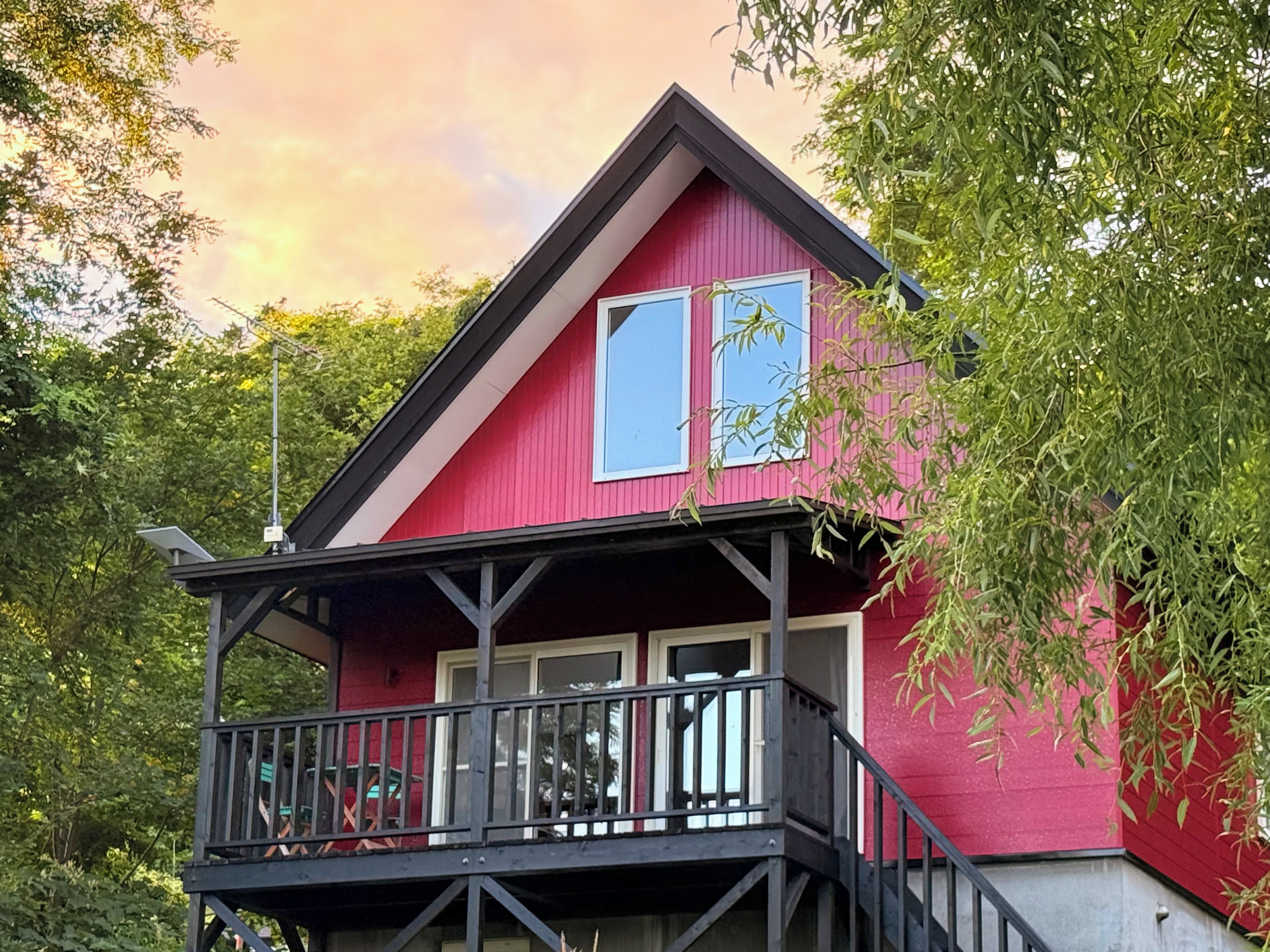 A red building with a balcony and a staircase.