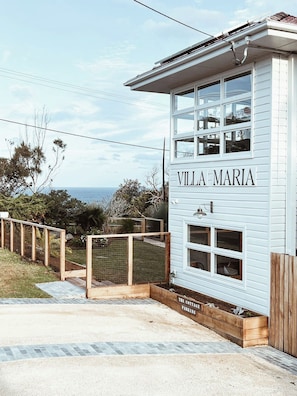 A two-story building named 'VILLA MARIA' with a sign indicating 'THE COTTAGE PARKING'. - Restored Vintage Seaside Home with Pacific Ocean Views (Port Macquarie)