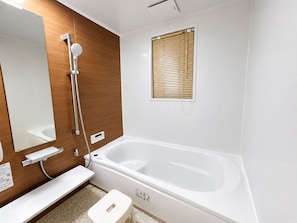 Un baño moderno con bañera, ducha e inodoro.
