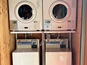 Twee gestapelde wasmachines met bedieningspanelen en een digitaal scherm.