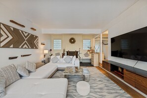 A modern living room with a sectional sofa, a flat-screen TV, and a fireplace. - 2BR Queen Anne Home - Space Needle View + Deck (Seattle)