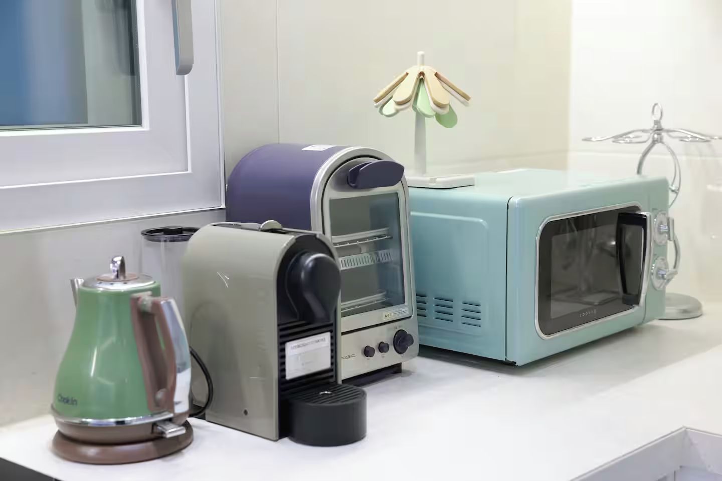 Una cocina equipada con cafetera, tostadora y microondas.