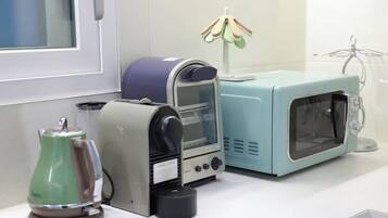 Una cocina equipada con cafetera, tostadora y microondas.