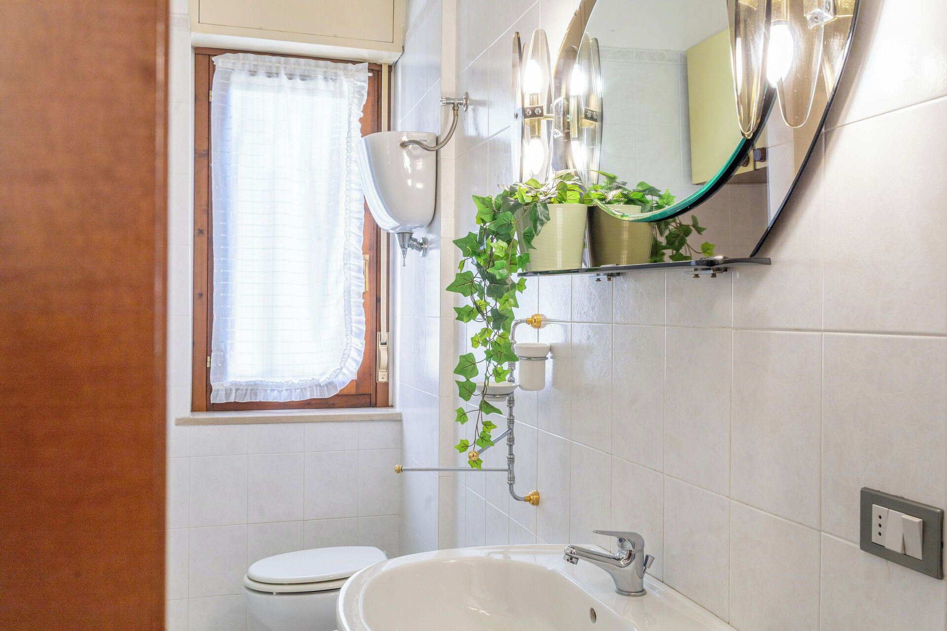 Ein Badezimmer mit Toilette, Waschbecken und einem beleuchteten Spiegel.