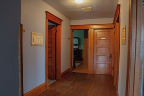Un pasillo con puertas de madera y un cartel enmarcado en la pared.