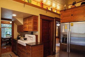A kitchen with wooden cabinets, a stainless steel refrigerator, and a white countertop.