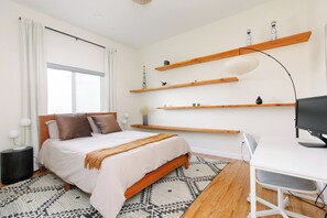 A modern bedroom with a bed, bedside table, and a desk with a chair. - California dreamin hilltop views! 4 bedrooms & 3 full baths (Los Angeles)