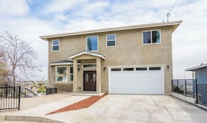 A two-story house with a garage, a front porch, and a driveway. - California dreamin hilltop views! 4 bedrooms & 3 full baths (Los Angeles)