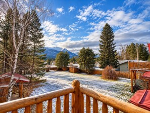 A wooden deck with a view of a snowy landscape, trees, and a mountain in the background. - Cranberry Mountain Lodge - Valemount (Valemount)