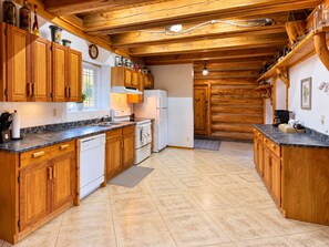 Eine Küche mit Holzschränken, einem Herd und einem Kühlschrank.