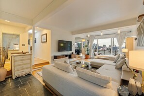 A modern living room with a sofa, coffee table, and a flat-screen TV mounted on the wall. - Entire Queen Anne House - 3BR Space Needle View (Seattle)