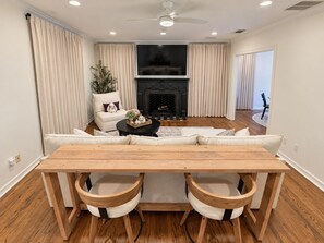 Una sala de estar moderna con sofá, chimenea y una mesa de comedor con sillas.