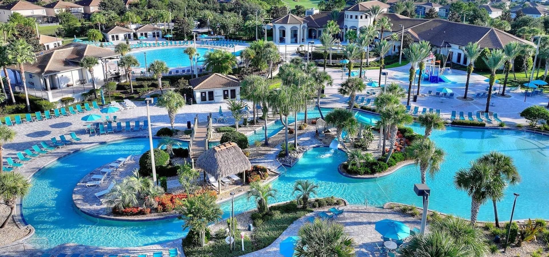 A resort with multiple swimming pools, palm trees, and lounge areas.