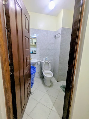 A bathroom with a toilet, sink, and shower area. - Peaceful Syokimau Stay Near Airport (Mlolongo)