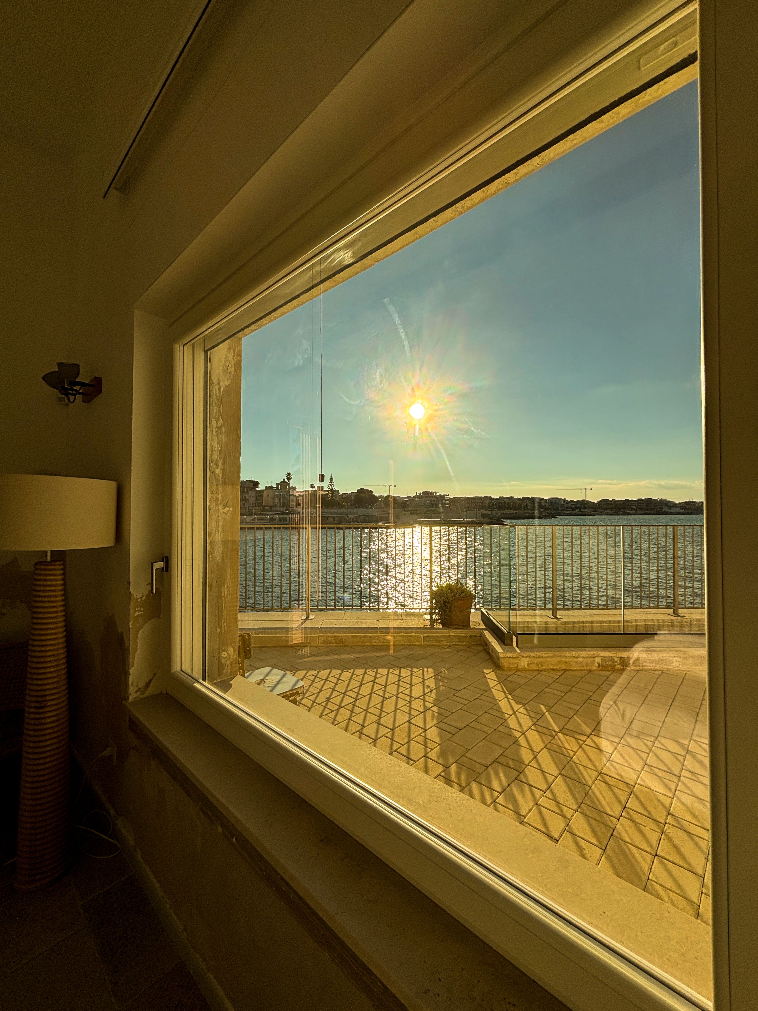 A window with a view of a waterfront and a cityscape.