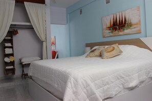 Ein Schlafzimmer mit einem Bett, einem Nachttisch, einem Gemälde und einem Kleiderschrank.