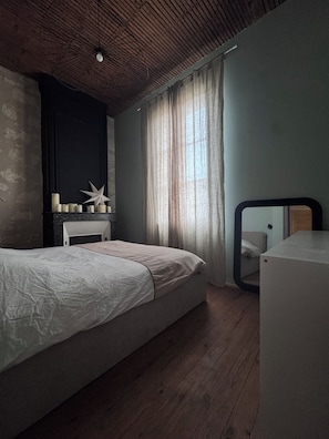 A bedroom with a bed, a dresser, a mirror, and a window with curtains. - Bordeaux-style townhouse with a garden, a 5-minute walk from the train station (Bordeaux)