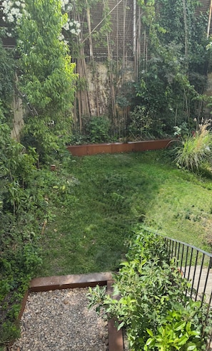 A garden with a variety of plants and a wooden fence. - Bordeaux-style townhouse with a garden, a 5-minute walk from the train station (Bordeaux)