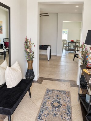 A modern living room with a black sofa, a patterned rug, and two vases with flowers. - A home away from home! A very spacious and comfortable place to relax! (Orlando)