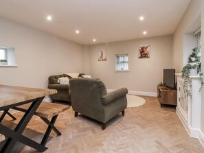 Ein Wohnzimmer mit einer Couch, einem Couchtisch und einem Fernseher.