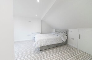 A bedroom with a bed, a radiator, and a wardrobe. - A Little Home of Your Own in Poulton — Gated Entrance & Parking (Poulton-le-Fylde)