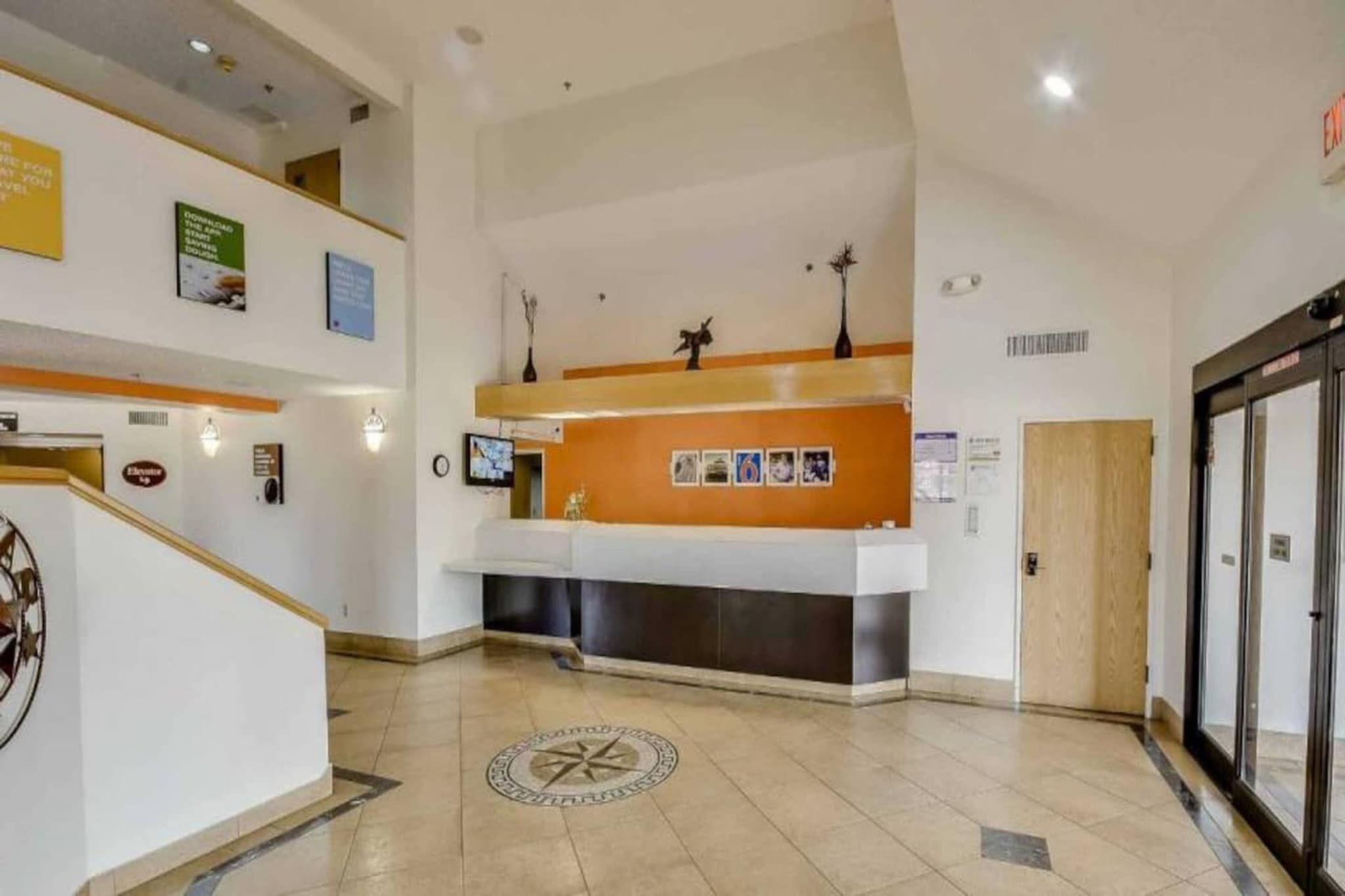 A reception area with a counter, a clock, and a door.