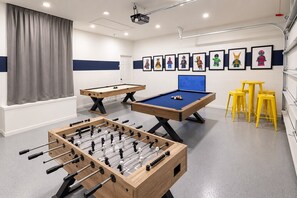 A room with a foosball table, two pool tables, and a projector screen. - Lakefront near Disney: Pool + LEGO game room (Kissimmee)