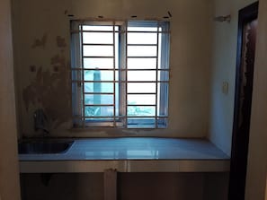Eine Küche mit Fenster, Spüle und Tür.