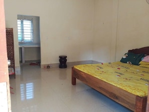 A room with a bed, a small stool, a window, and a door. - 3-bedroom house in beautiful Siem Reap with cool AC (Krong Siem Reap)