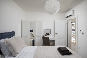 Een slaapkamer met een bed, een bureau, een stoel en een kledingkast.