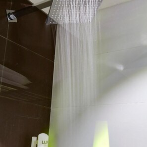 Una ducha con diseño moderno, un flujo de agua visible y una estructura metálica.
