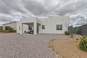 A modern two-story house with a patio area, a covered outdoor seating space, and a gravel driveway. - Modern Rio Rico Home Near Nogales & Lake Rec! (Rio Rico)