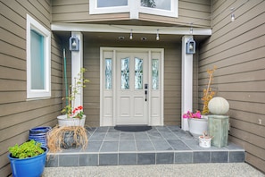 A house with a front door, two potted plants, a doormat, and a small step leading up to the door. - 4-Unit Group Retreat! 2 Hot Tubs & Walk to Beach (Hansville)
