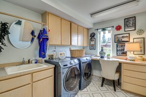 A laundry area with a washing machine, a sink, and a chair. - 4-Unit Group Retreat! 2 Hot Tubs & Walk to Beach (Hansville)