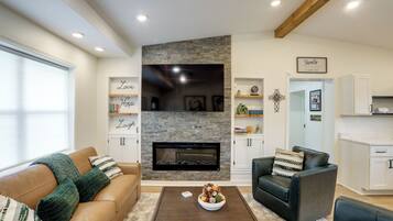 Una sala de estar con chimenea de piedra, sofás de cuero y una mesa de centro.