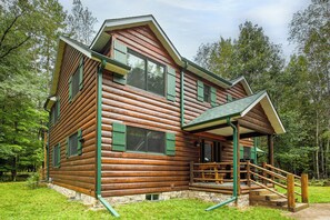 Eine Blockhütte mit Veranda und Natursteinfundament.